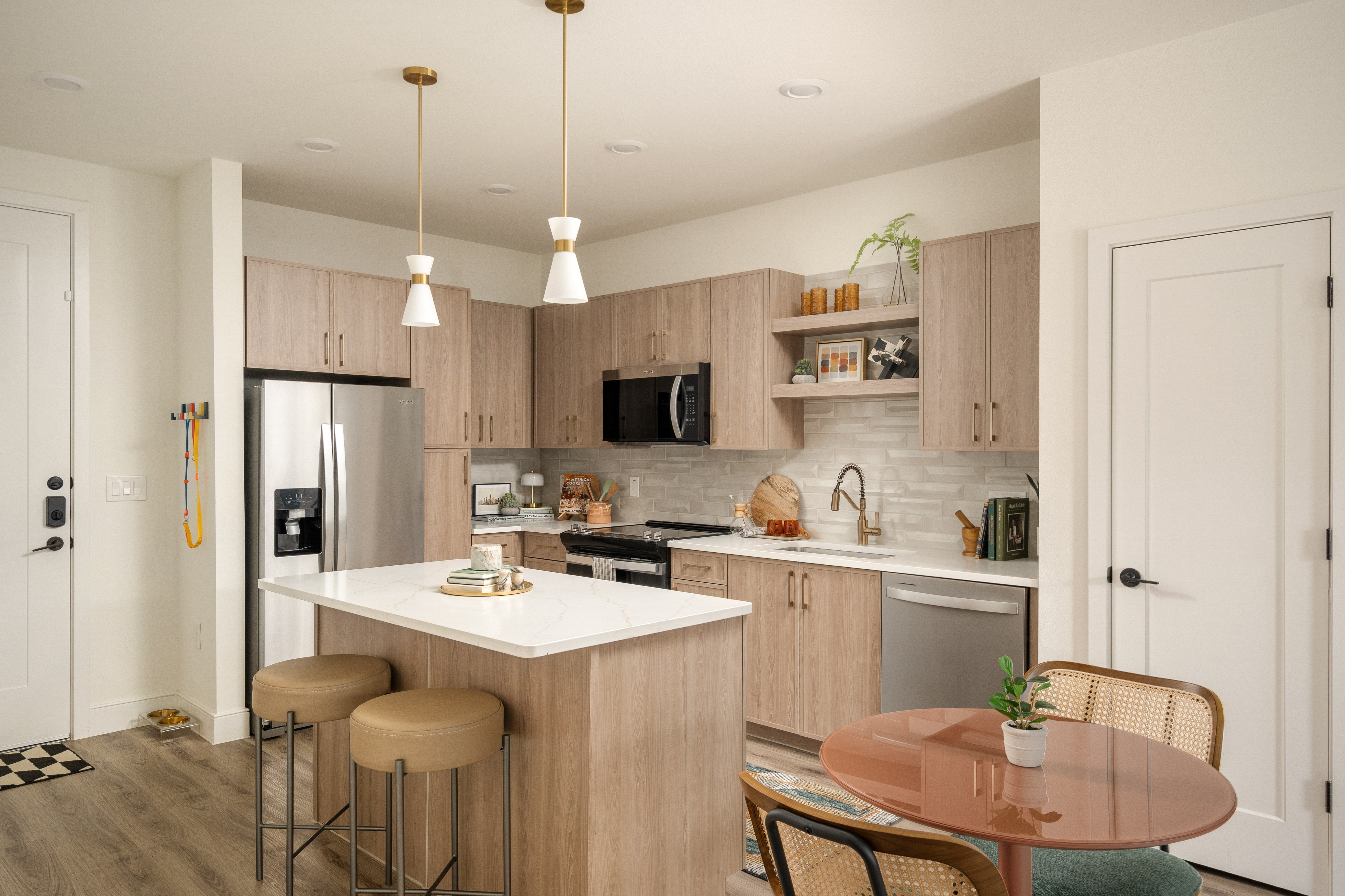 A kitchen with a refrigerator, microwave, and oven.